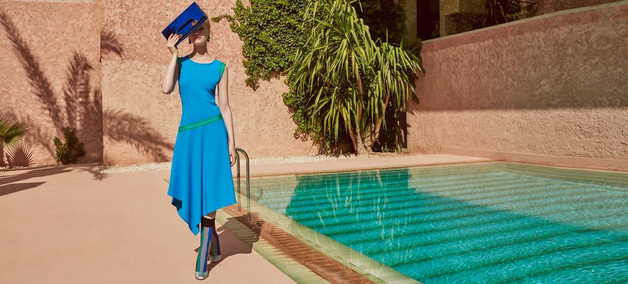 Model in blauem Sommerkleid am Pool in Marrakech